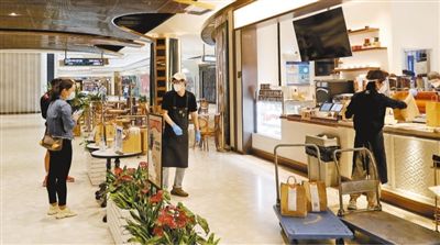 5月20日，市民在位于上海浦东新区前滩太古里购物中心内的一家咖啡店自提网络订单货品。当日，该购物中心重新开启线下营业模式，部分店铺有序开业复商复市。新华社记者 方喆摄