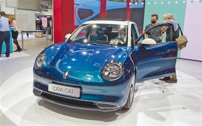 一家中国车企在德国举行的车展上向观众展示最新款电动汽车。  本报记者 李 强摄