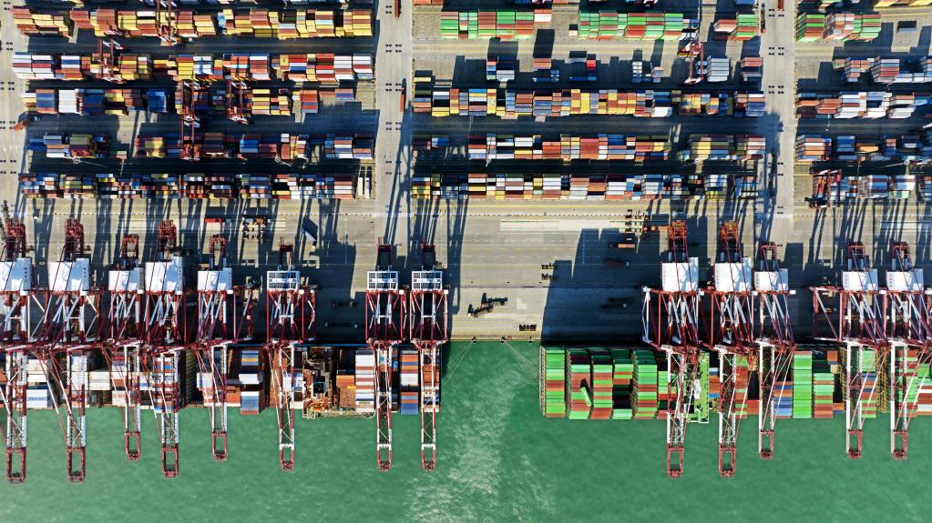 1月27日，集装箱货轮在青岛港前湾集装箱码头装卸货物（无人机照片）。新华社记者李紫恒摄