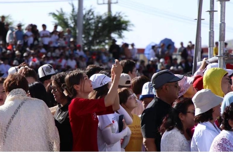 现场观众拿起手机记录精彩瞬间。人民网 李龙摄 现场观众拿起手机记录精彩瞬间。人民网 李龙摄