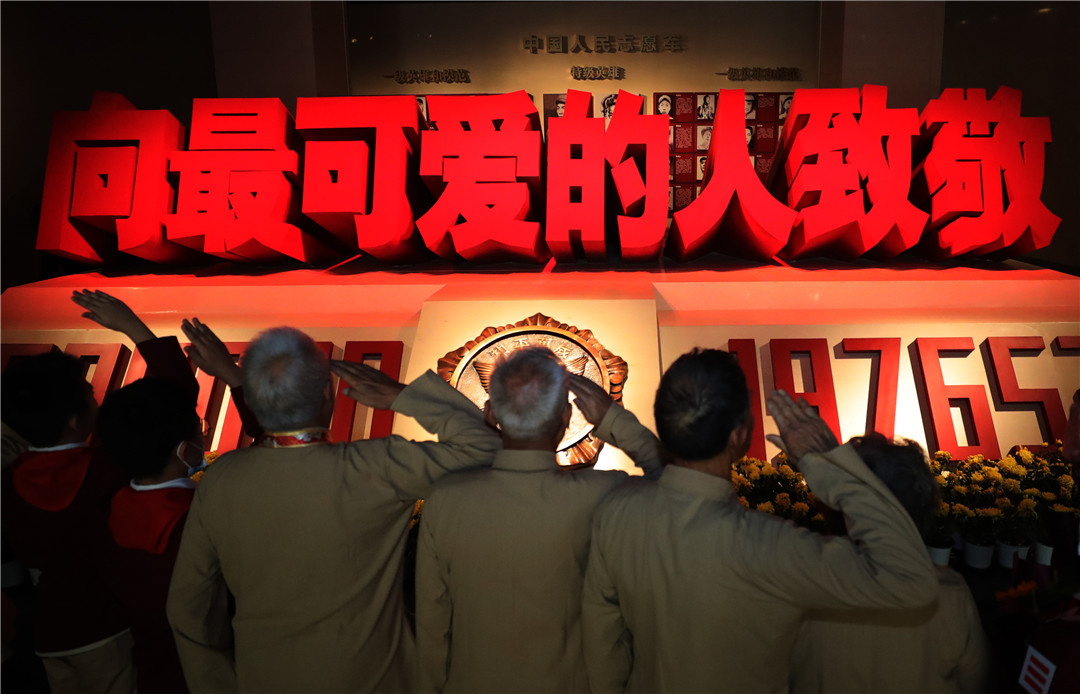 在抗美援朝纪念馆英烈厅，志愿军老战士和少先队员向牺牲的烈士致敬。新华社记者杨青 摄