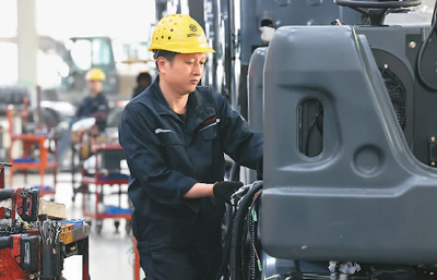 福建省泉州市洛江区持续优化营商环境，落实税收优惠政策，以数字经济新动能推动制造业企业发展。图为12月6日，在福建省泉州市洛江区一家轮式挖掘机生产企业数字化生产车间，工人在组装挖掘机。  王旺旺摄（人民视觉）