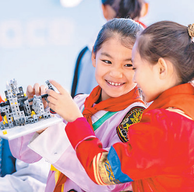 内蒙古呼和浩特市，小学生在校学习组装机器人。丁根厚摄（影像中国）