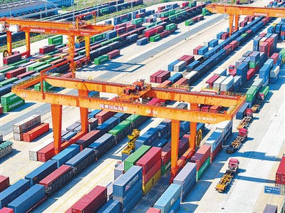江西赣州国际陆港采取“铁海联运”方式，助力出口“新三样”产品之一的新能源汽车加速“出海”。图为日前在赣州国际陆港货运场站，吊装设备装运出口海外的新能源汽车货箱。  朱海鹏摄（人民视觉）