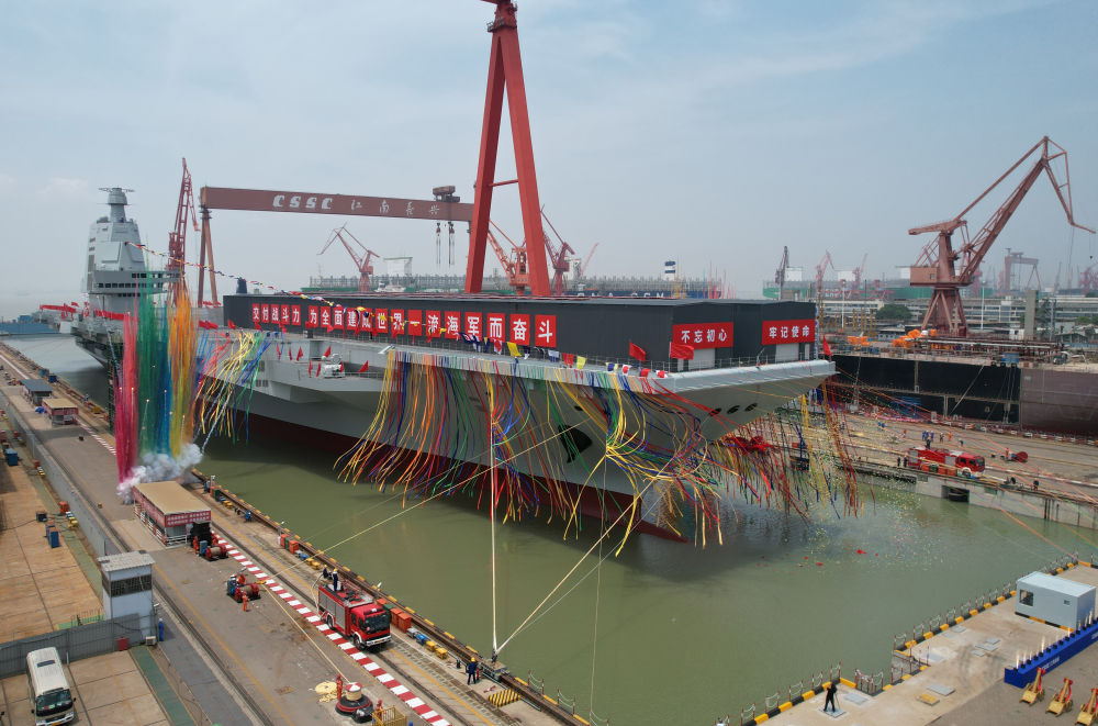 2022年6月17日上午，我国第三艘航空母舰下水命名仪式在中国船舶集团有限公司江南造船厂举行。经中央军委批准，我国第三艘航空母舰命名为“中国人民解放军海军福建舰”，舷号为“18”。福建舰是我国完全自主设计建造的首艘弹射型航空母舰，采用平直通长飞行甲板，配置电磁弹射和阻拦装置，满载排水量8万余吨。新华社记者 李刚 摄