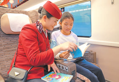 从北京开往南昌的列车上,乘务人员与小旅客一起阅读。王梦婧子摄 从北京开往南昌的列车上,乘务人员与小旅客一起阅读。王梦婧子摄