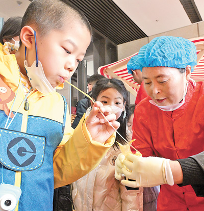 北京中国非物质文化遗产馆，小朋友在“过年——春节主题展”上体验吹糖人。　新华社记者 李 贺摄