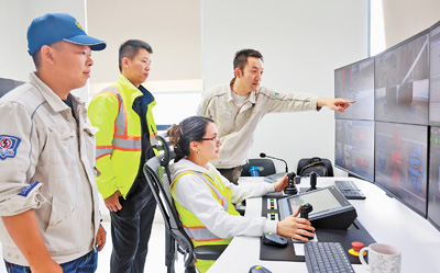 春节期间，秘鲁钱凯港的中秘员工仍坚守岗位。这是两国员工在远程操控设备。　本报记者 宋亦然摄