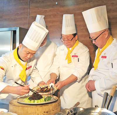 沈阳鹿鸣春饭店厨师在制作葱烧辽参。受访者供图