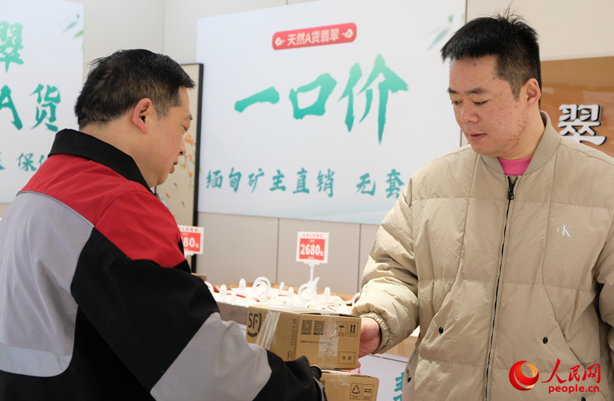 任秀林把包裹送到顾客手上。人民网记者 常力元摄